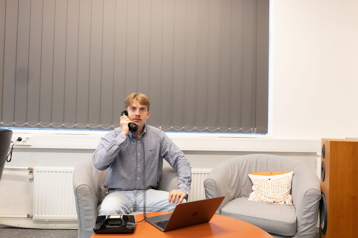 Onni Lampikoski working at a desk with a laptop and a telephone